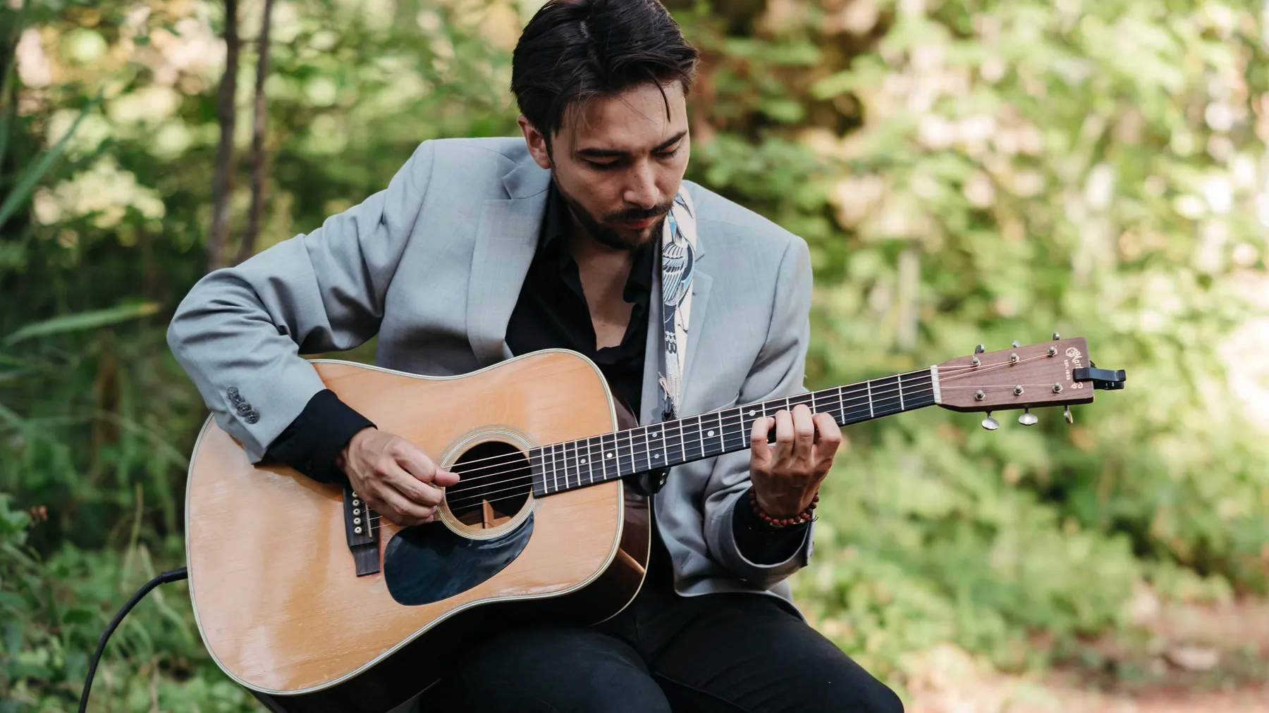 Alex Nishi playing guitar outdoors