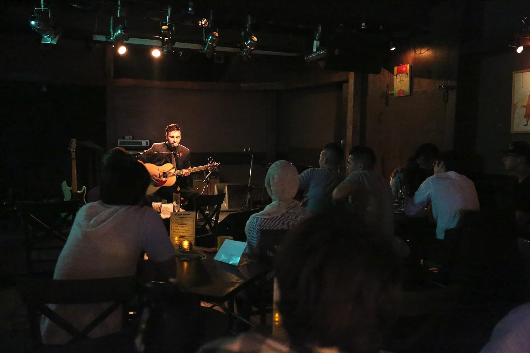 Alex Nishi performing solo acoustic to a seated audience